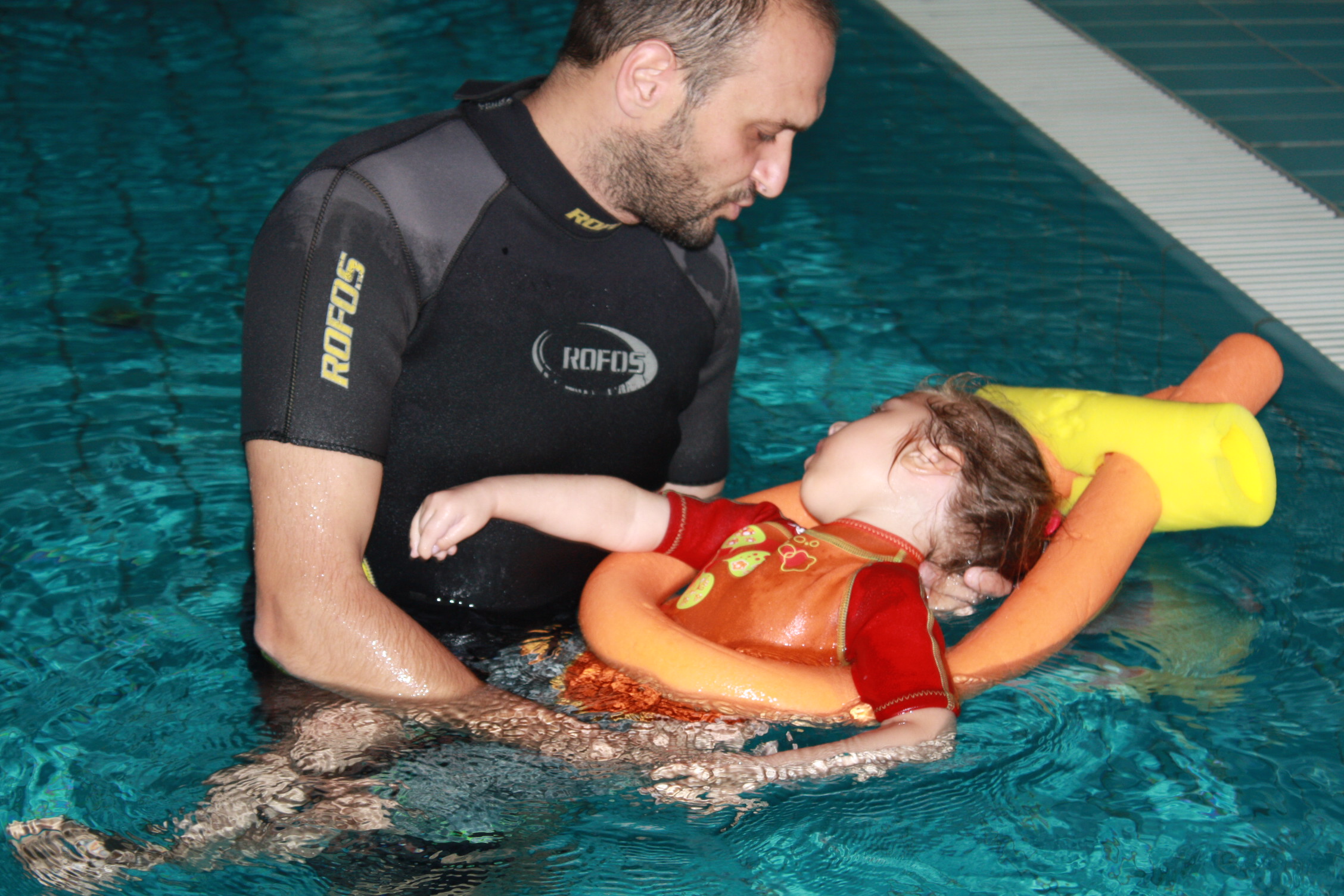 L'istruttore esegue una manovra riabilitativa in acqua